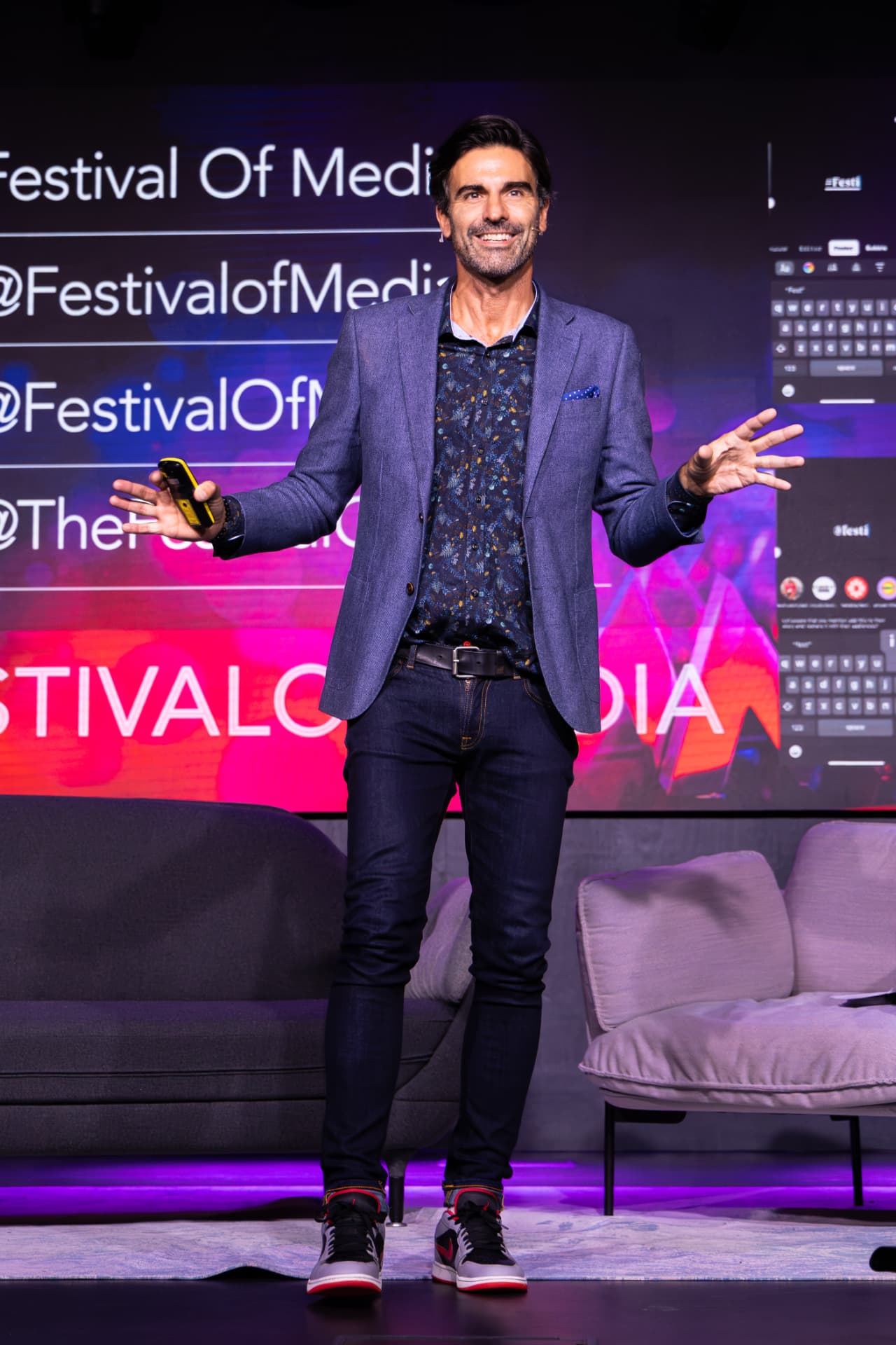 Host presenting on stage at the Festival of Media