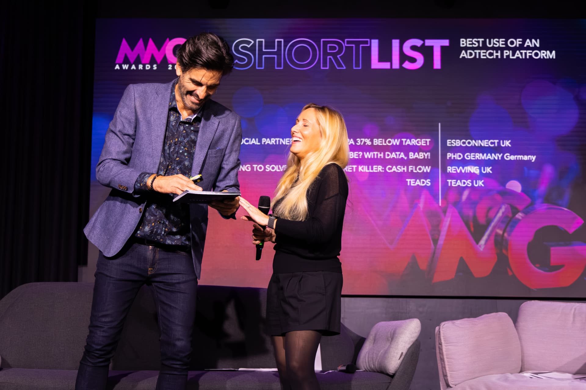 Hosts laughing while reading the shortlist on stage