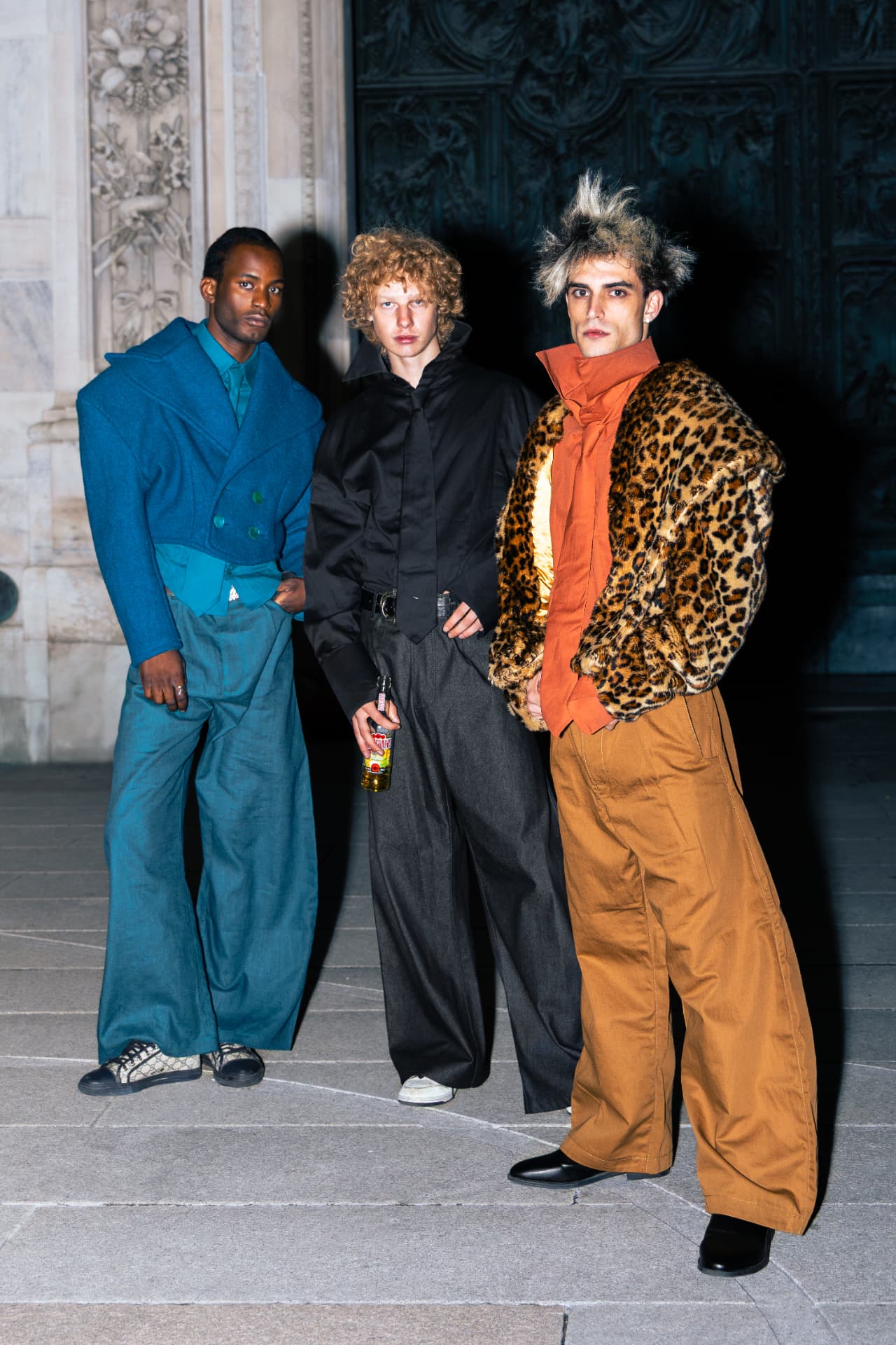 Three models standing together outside the cathedral