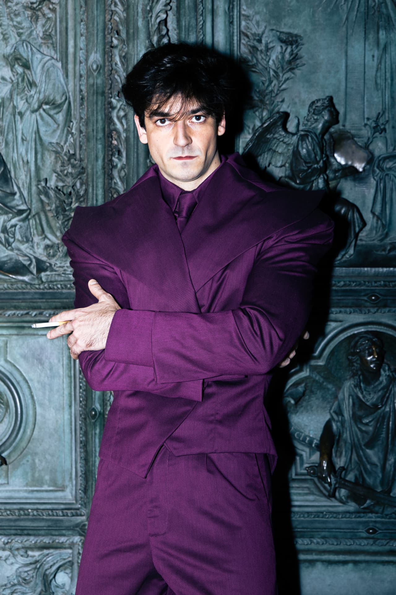 Portrait of a model in a purple suit, arms crossed
