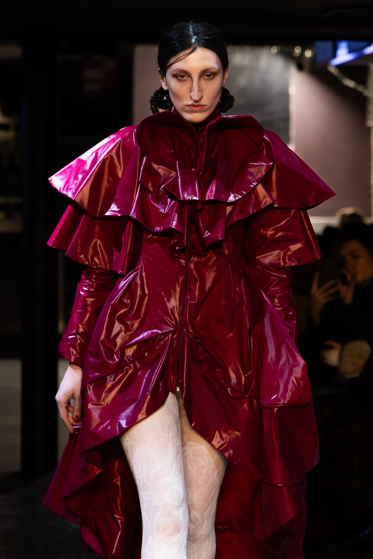 Model in a ruffled magenta patent coat