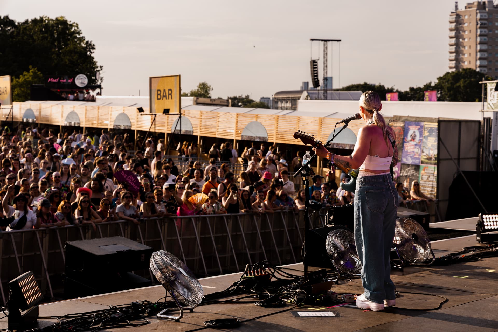 Performer facing a packed festival crowd at sunset