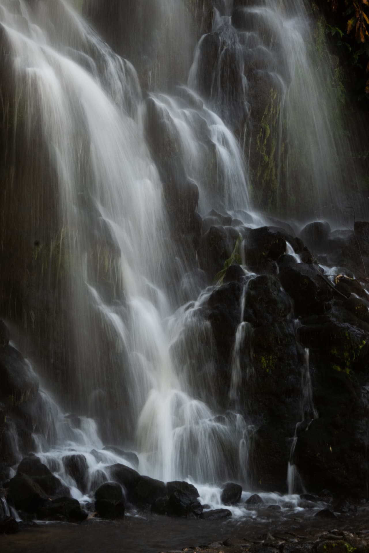 Waterfall cascading over dark volcanic rocks