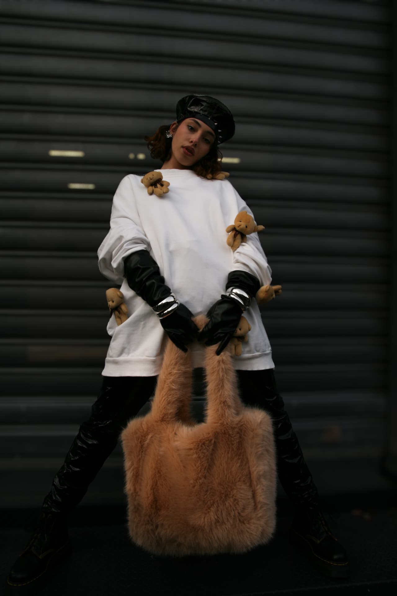Model in white sweatshirt with teddy bears and faux fur tote