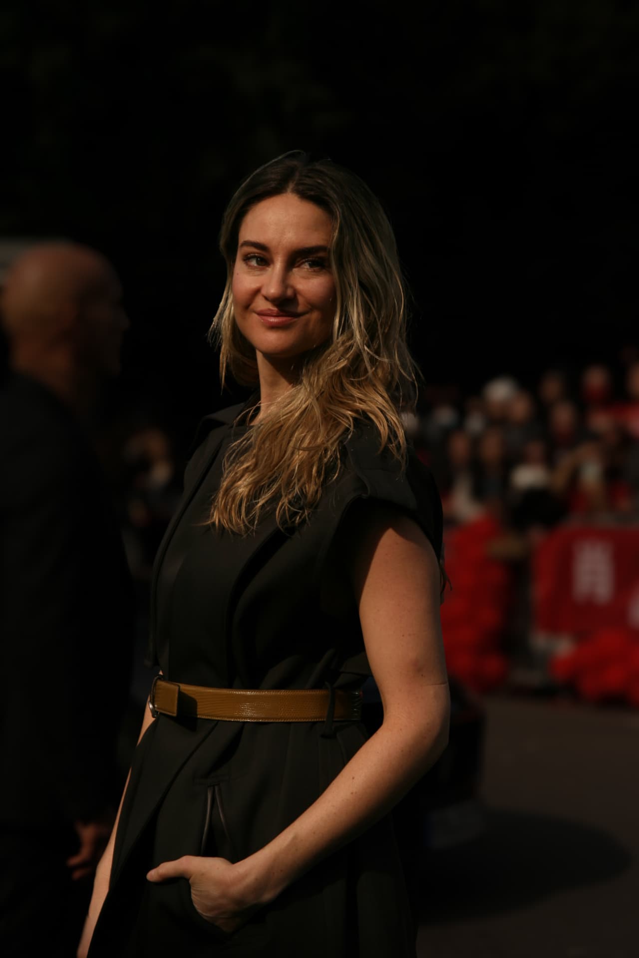 Guest in a black belted jumpsuit in low sunlight