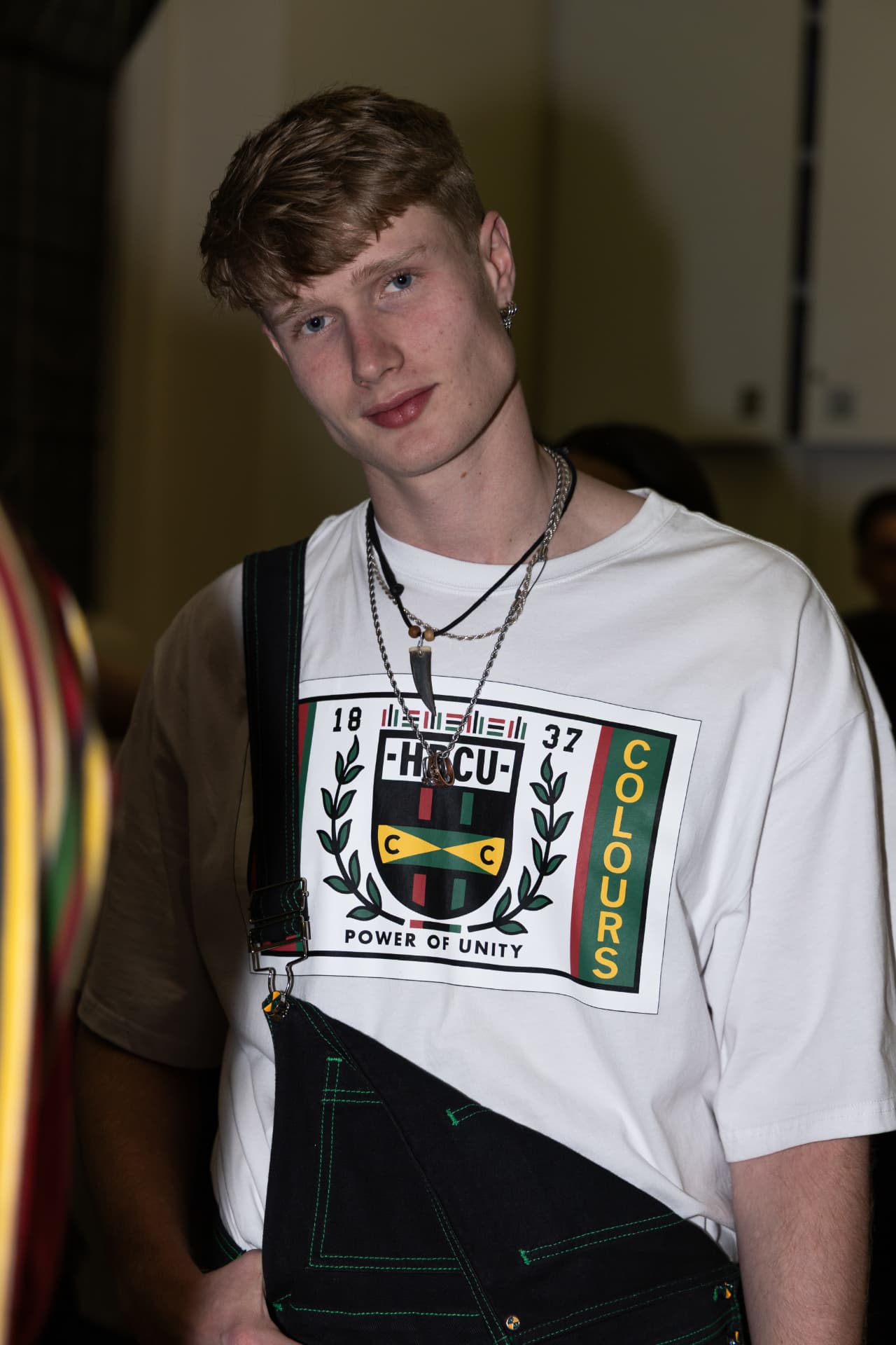 Model in white HBCU graphic t-shirt and black apron backstage