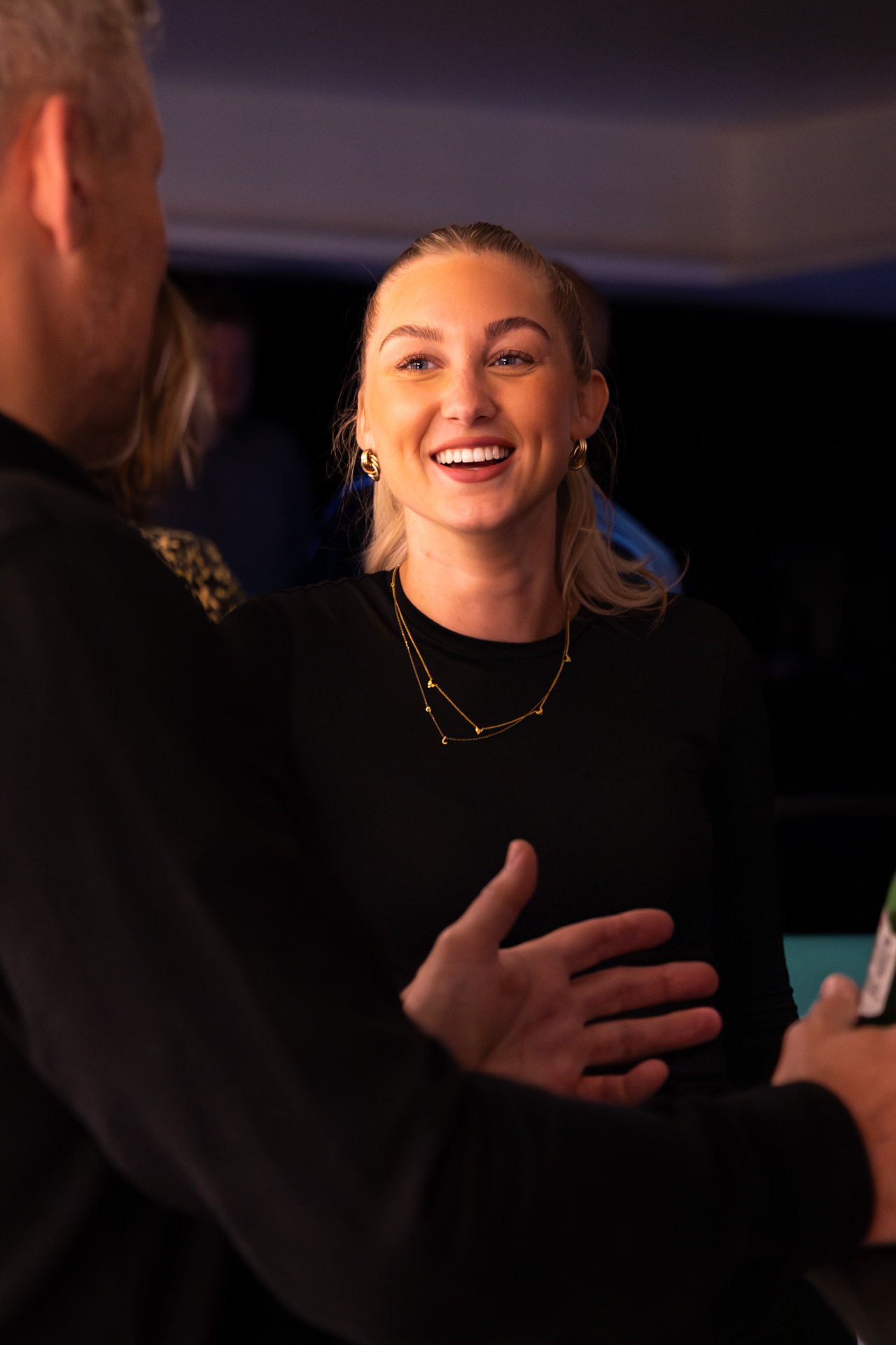 Guest laughing in conversation at the Amex Media Awards