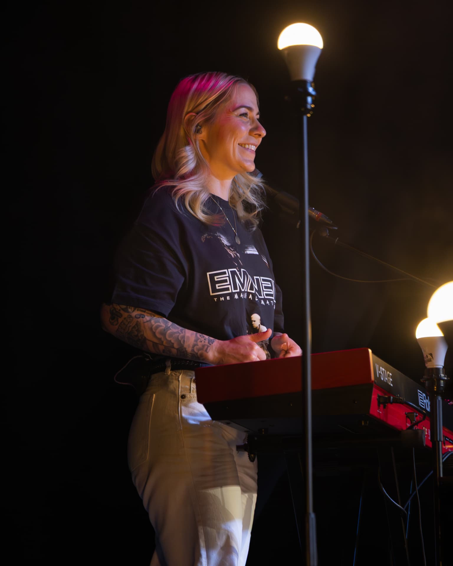 Laughing at the keyboard beside a warm stage lamp