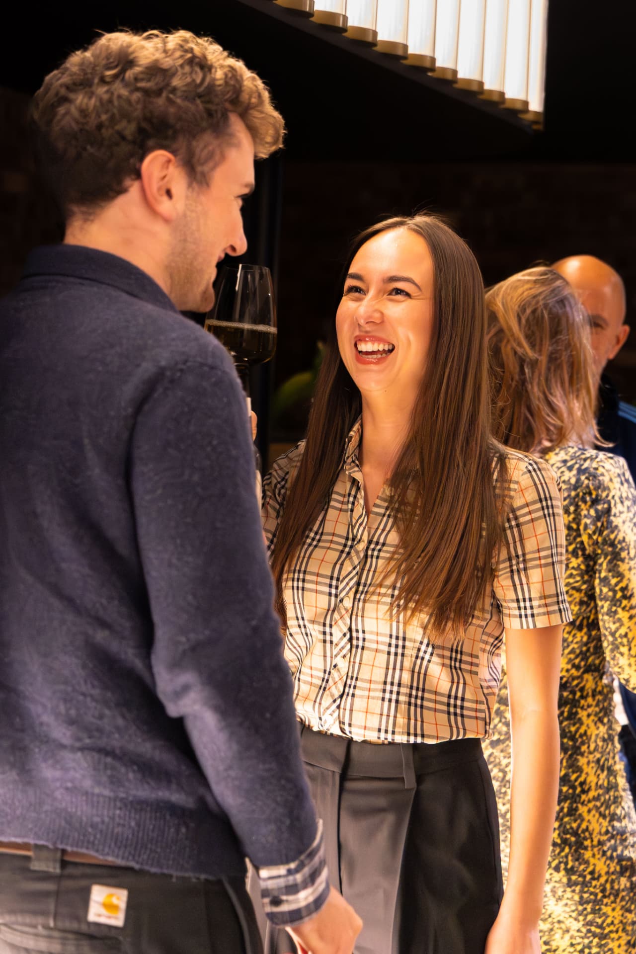 Two guests laughing together over drinks