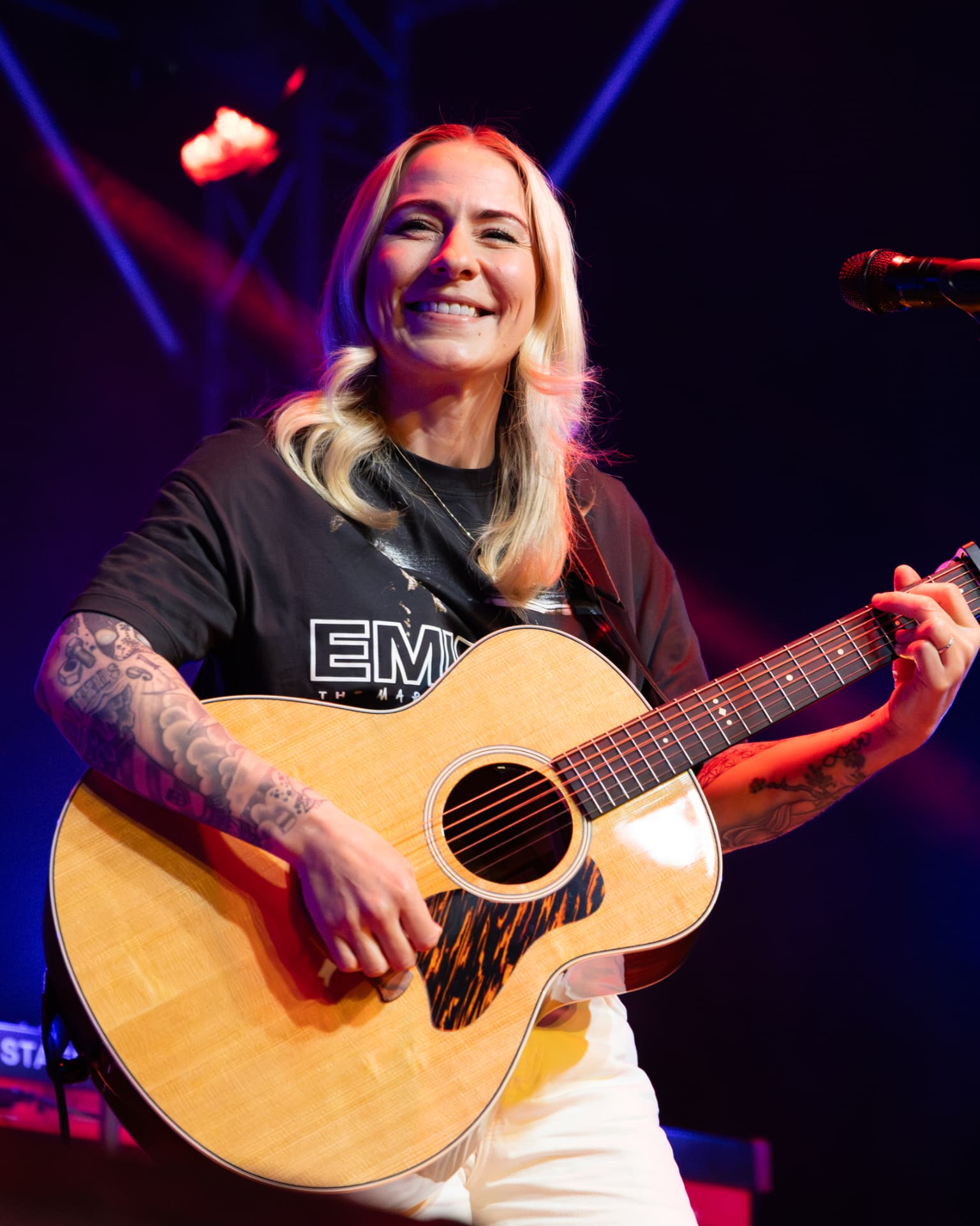 Close portrait of Lucy Spraggan laughing with her guitar