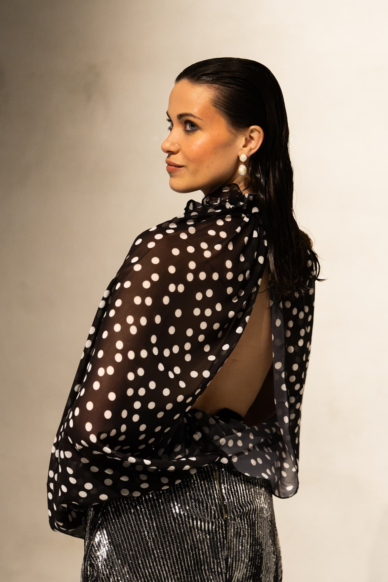 Model in polka dot sheer cape and sequin skirt