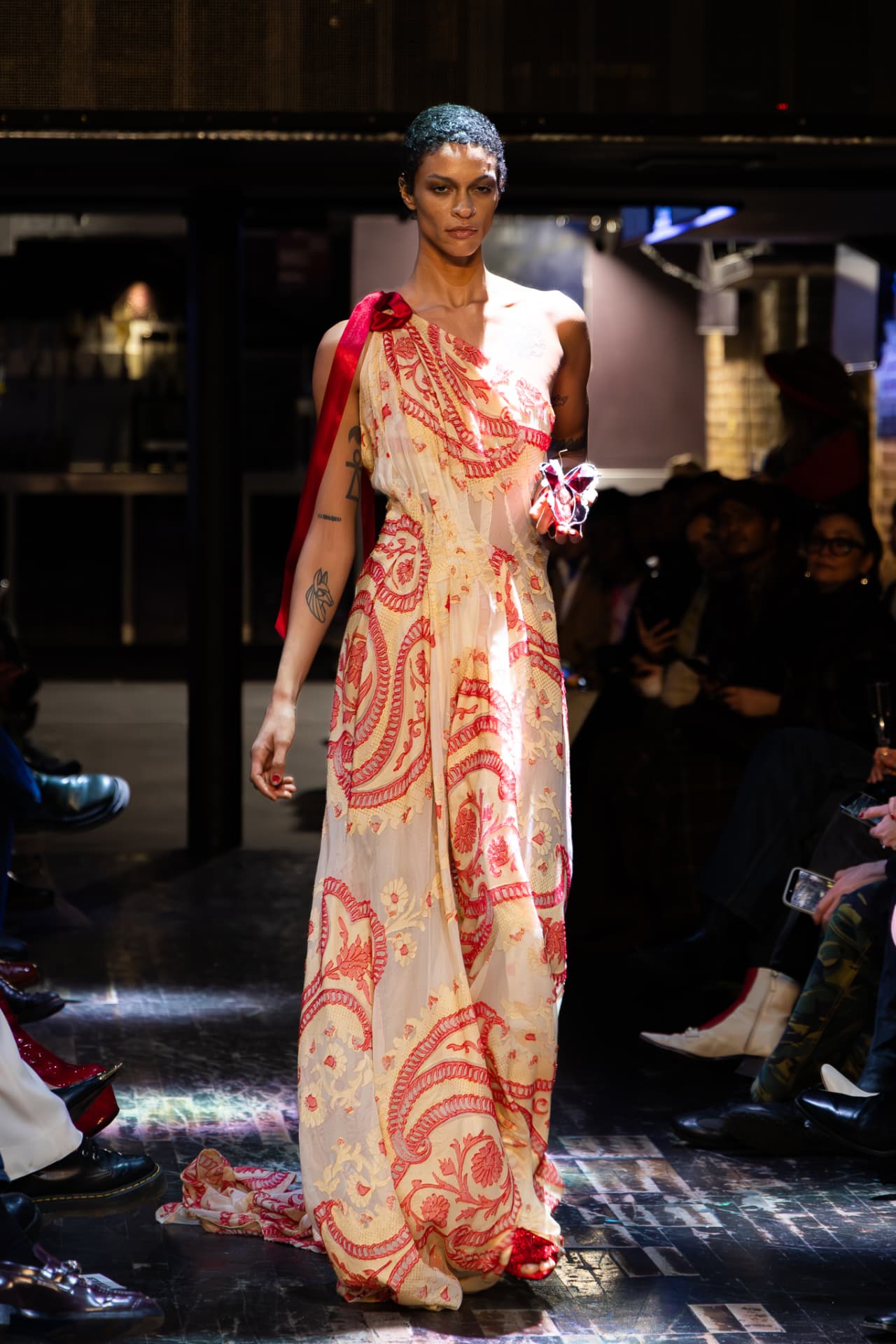 Model in a cream gown with red floral embroidery