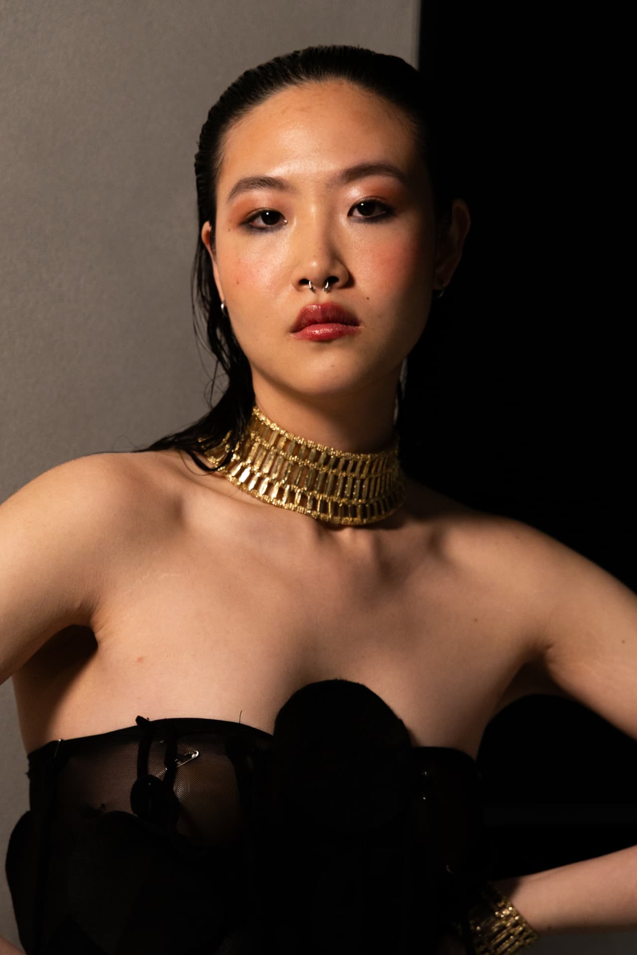 Portrait of a model in a gold choker and black strapless top