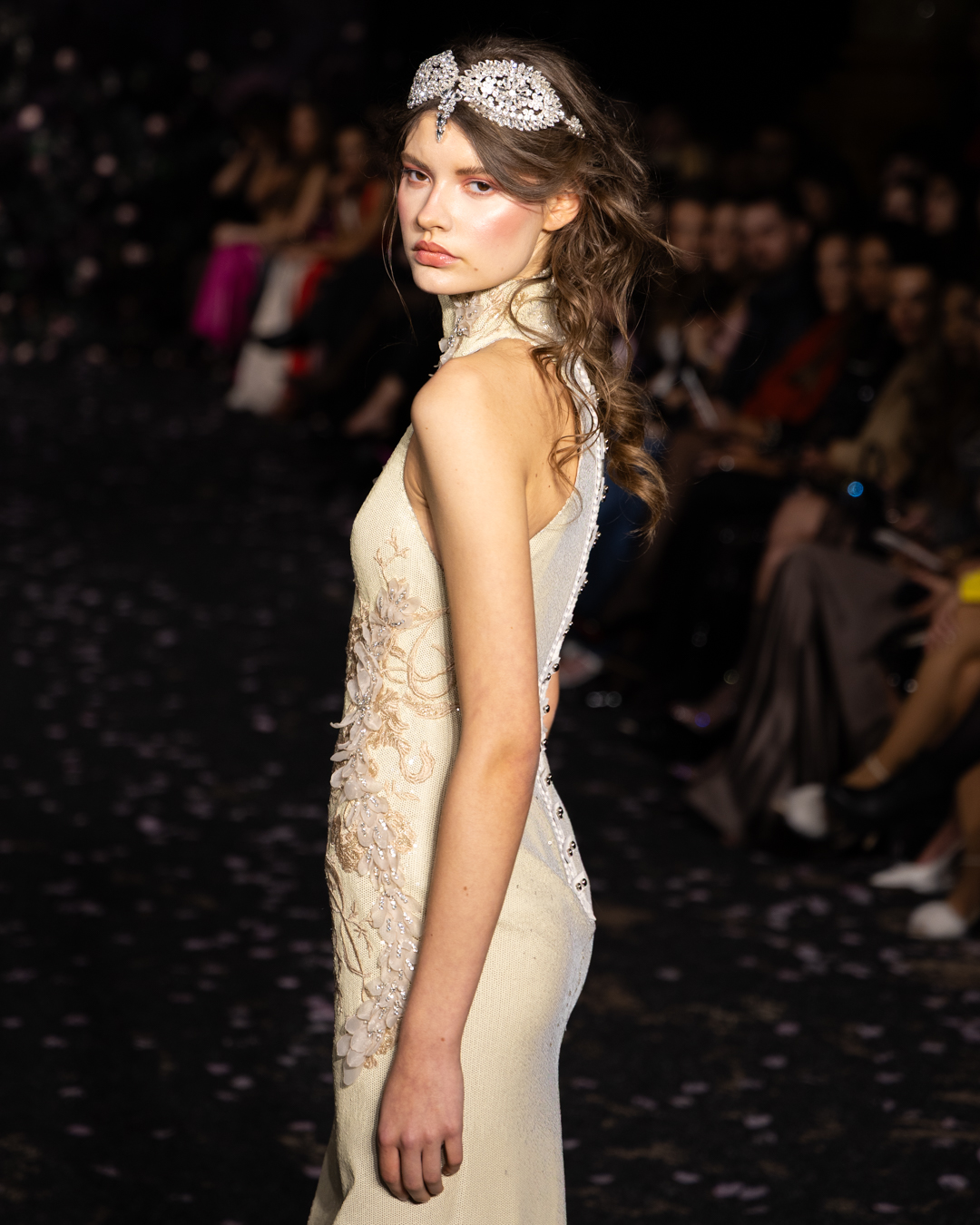 Side profile of a model in an ivory embroidered gown