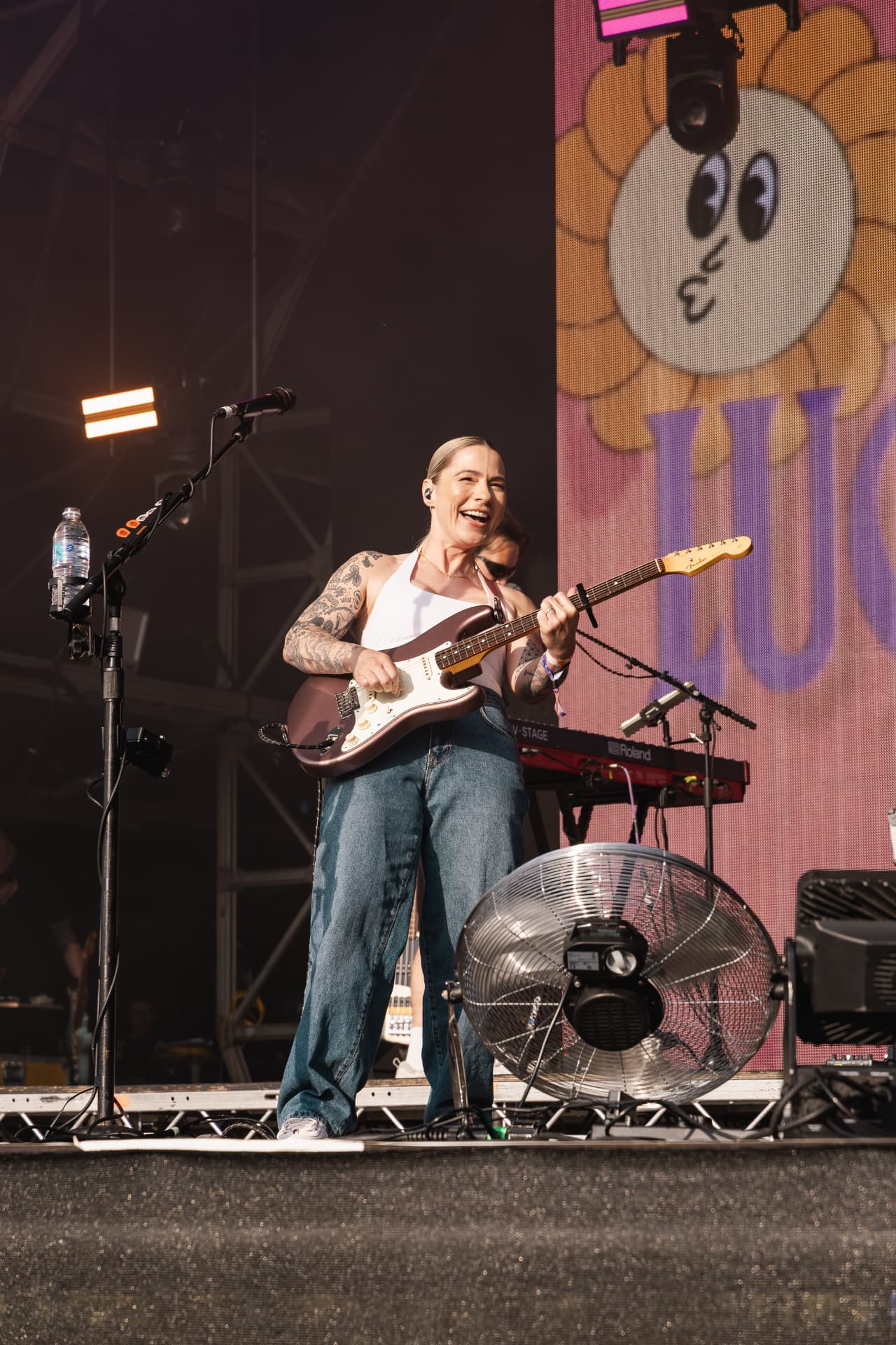 Singer laughing mid-song with guitar