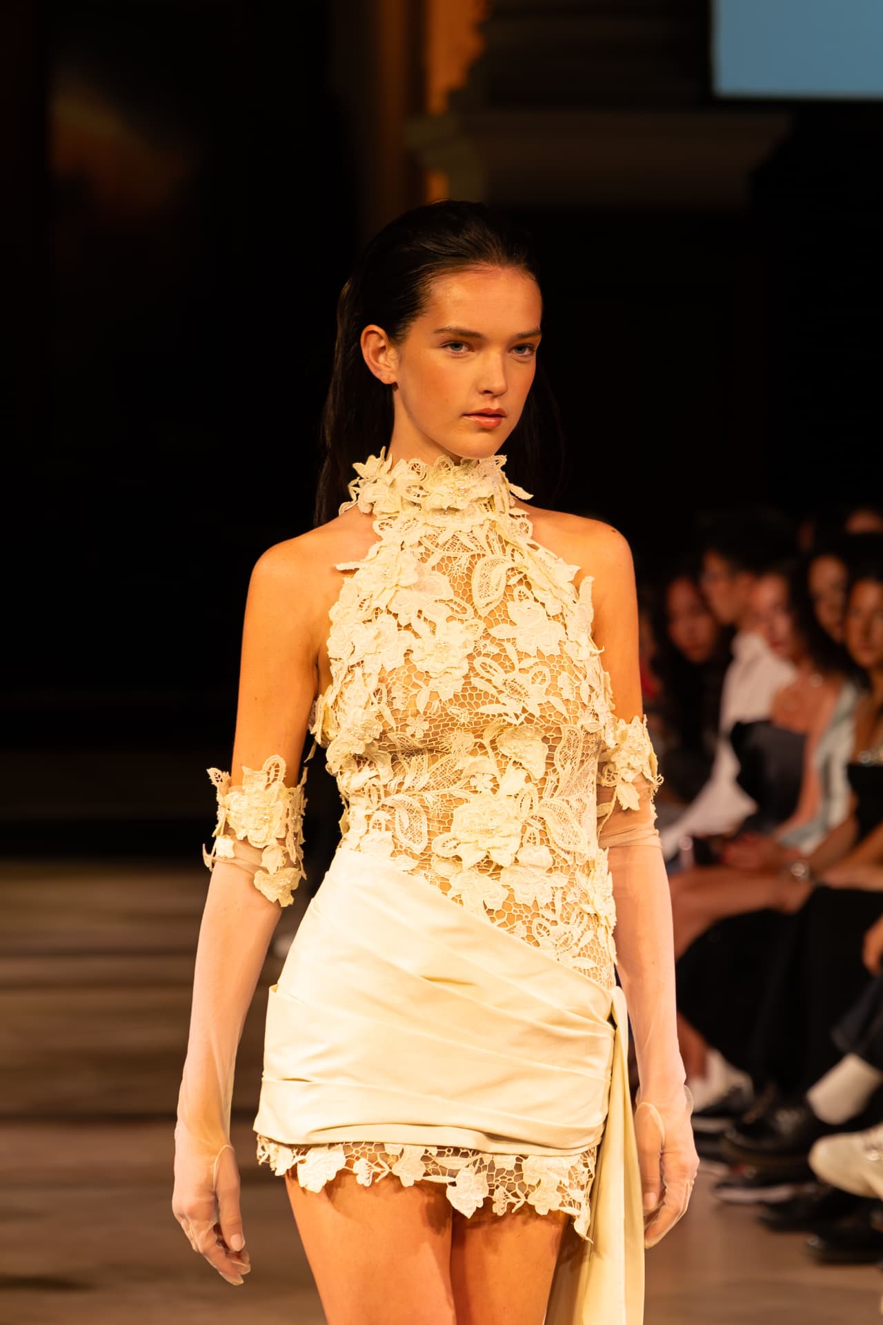 Model in a cream lace halter dress with satin skirt