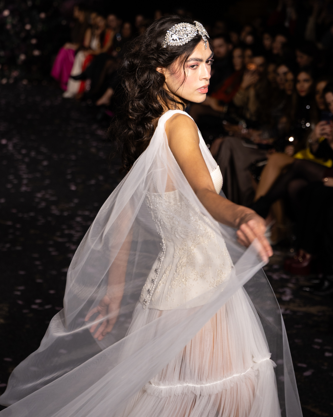 Model turning in a tulle gown with a flowing veil